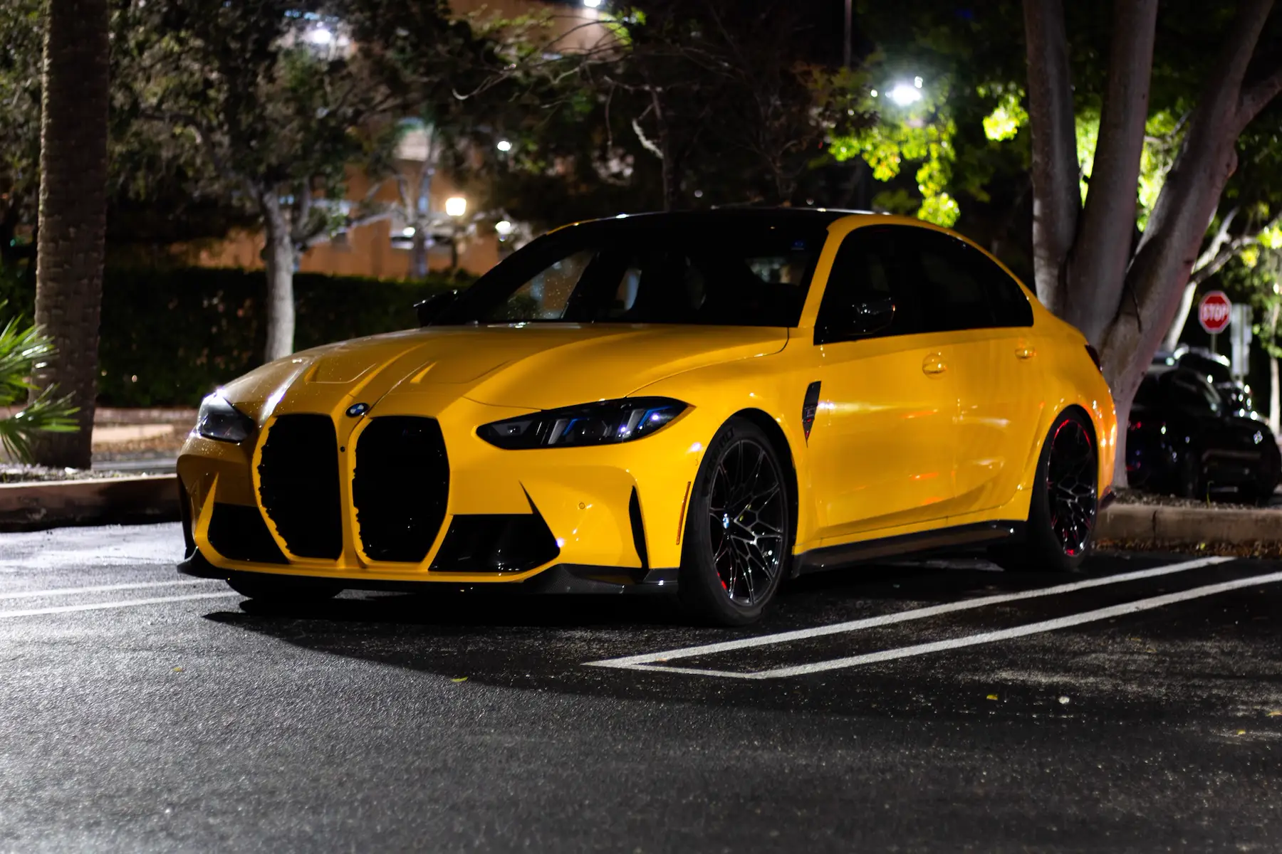 Yellow BMW M3 Competition at a UShift car meet at night, University of Miami, Coral Gables